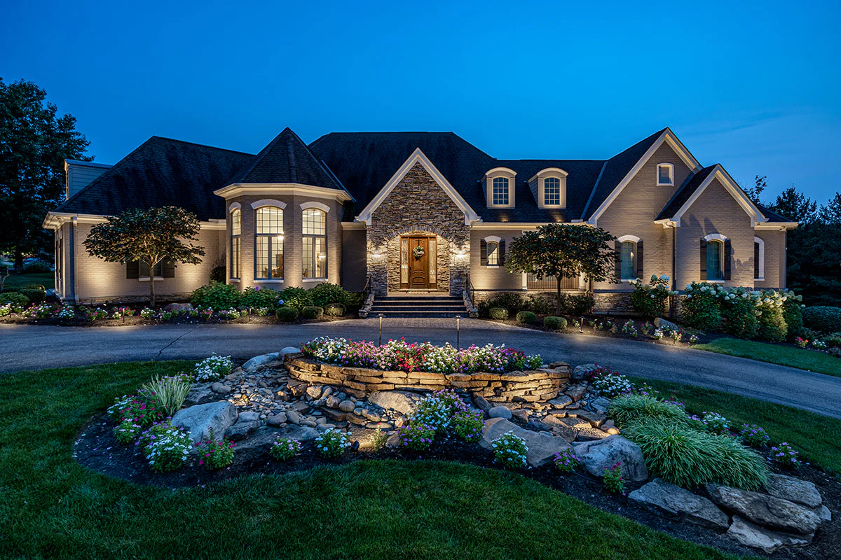 Luxury home exterior at night with full landscape lighting, Atlantic Electrical Services York County Maine