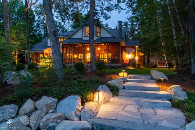 Maine lake house at dusk with path lighting and boulder steps, Atlantic Electrical Services project